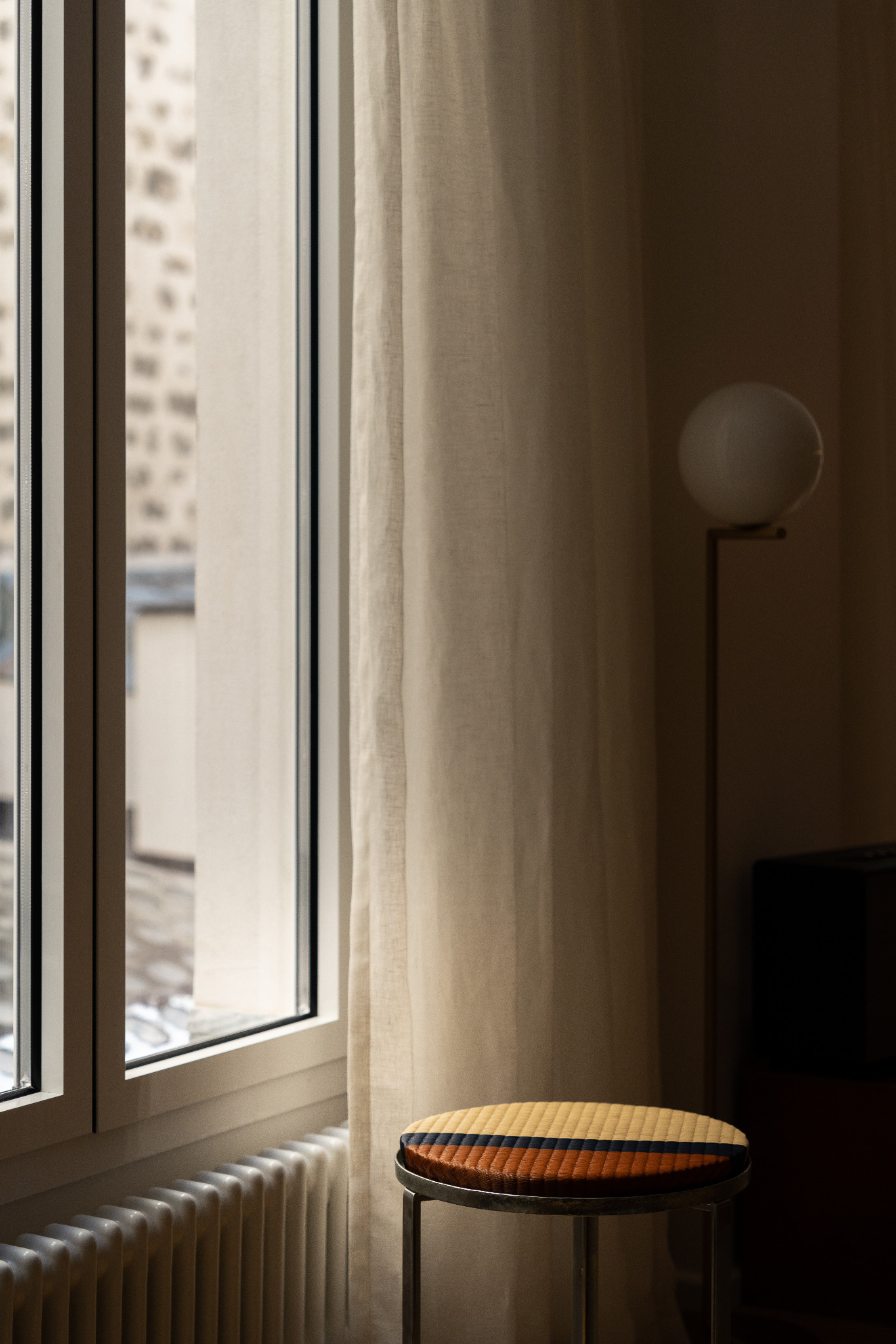 Fenêtre, rideau et tabouret dans une lumière douce