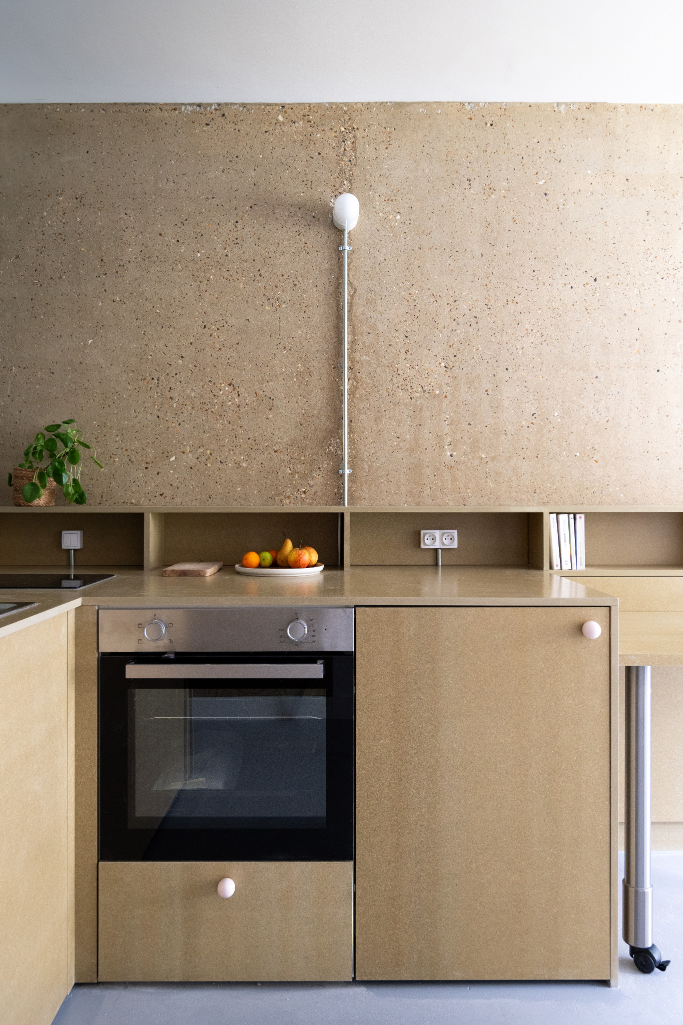 Cuisine compacte en bois sous un mur en béton brut